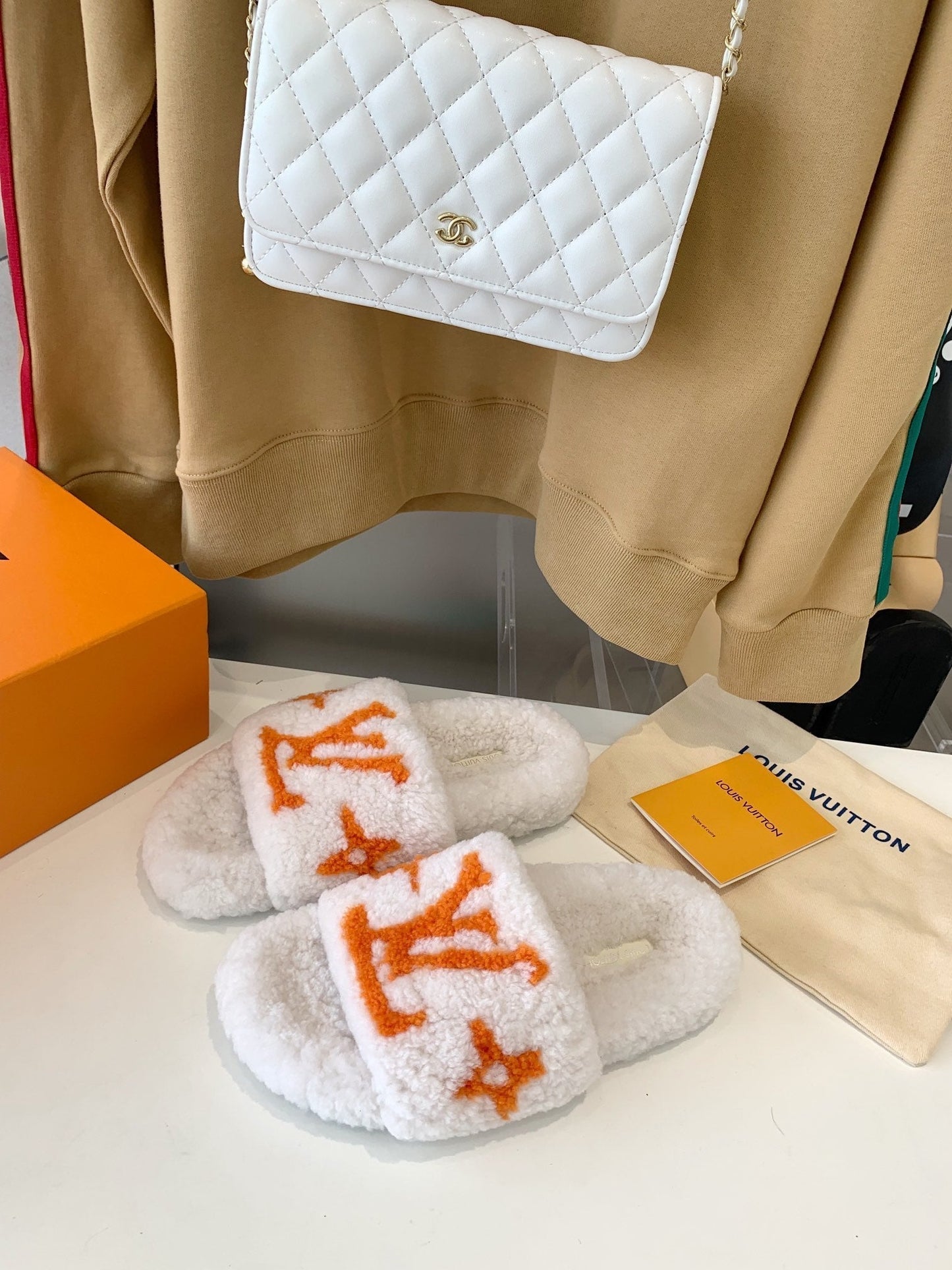 LV WOMEN'S PASEO FLAT SLIPPER IN WHITE FLEECE WITH ORANGE LOGO